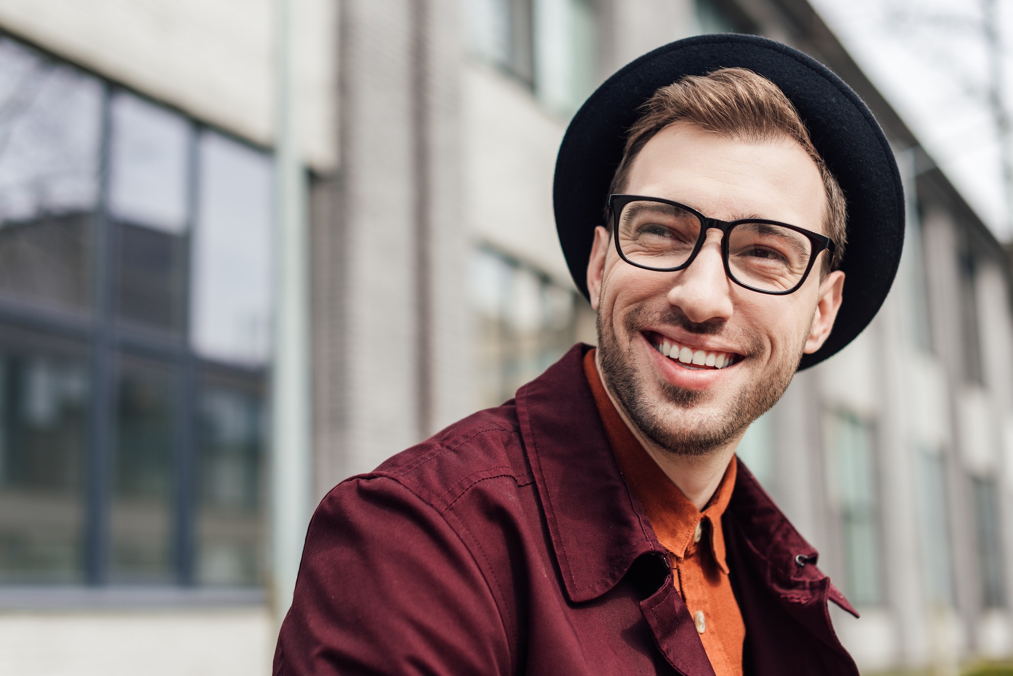 handsome cheerful man in eyeglasses and hat